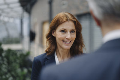 Portrait of smiling businesswoman talking to businessman in office