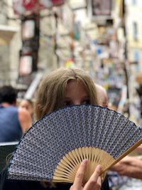 Girl holding hand fan at market