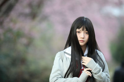 Portrait of a beautiful young woman standing outdoors