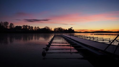 Pier on sea at sunset