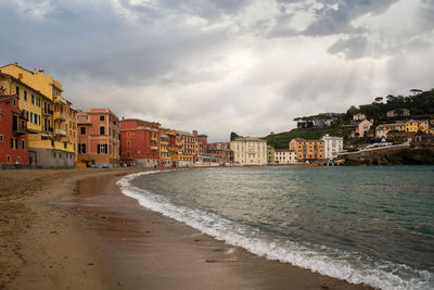 Fishing village with colored houses by the sea against dramatic sky, sestri levante, genova