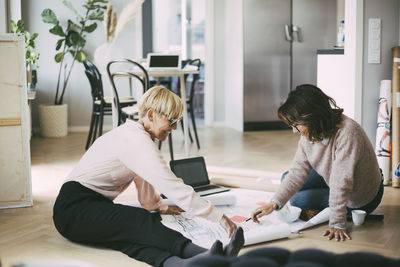 Architects sitting on the floor working on design plan