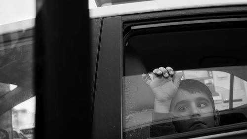 Portrait of man seen through car window