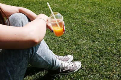 Low section of woman standing on grassy field