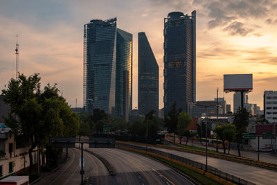 Buildings in city against sky during sunset