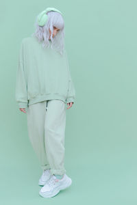 Full length of woman standing over colored background