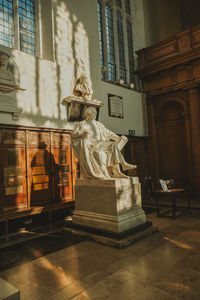 Statue against building in city