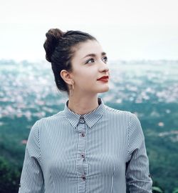 Young woman wearing red lipstick against landscape