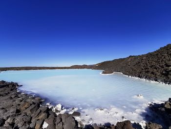 Scenic view of sea against clear blue sky