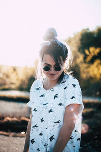 Woman wearing sunglasses standing against sky