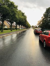 Cars on road against sky in rain