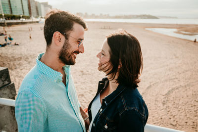 Couple embracing while standing on beach