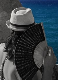 Rear view of woman with hat on sea shore