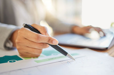 Midsection of businessman working on table