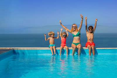 Young woman with arms raised in swimming pool