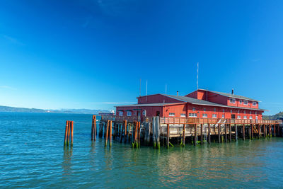 Wooden posts in sea against sky