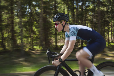 Man cycling along forest