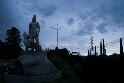 Statue against sky at dusk