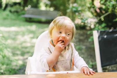 Close-up of cute girl eating food while sitting outdoors