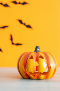 Close-up of jack o lantern on table against yellow wall