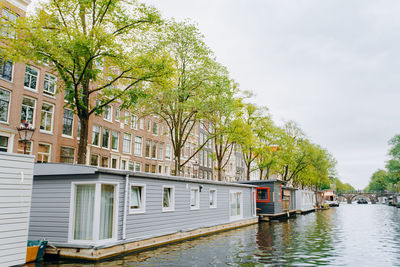 River amidst trees and buildings against sky