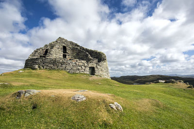 Old ruin on field against sky