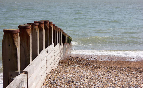 Wooden posts on beach by sea