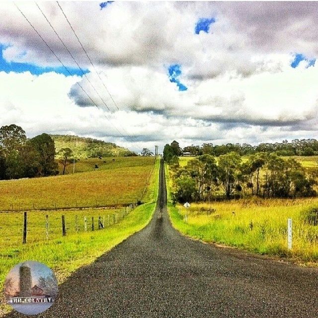 sky, the way forward, field, landscape, cloud - sky, road, rural scene, tranquil scene, diminishing perspective, tranquility, transportation, agriculture, grass, vanishing point, scenics, nature, beauty in nature, country road, cloudy, cloud