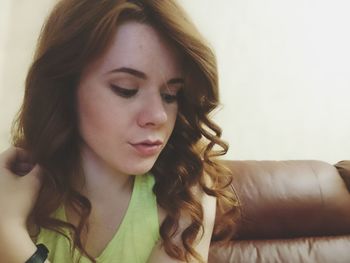 Close-up of woman sitting on sofa at home