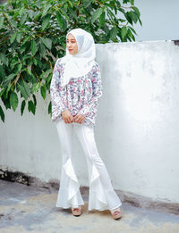 Rear view of woman standing against white wall