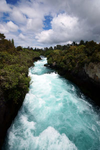 Scenic view of waterfall against sky