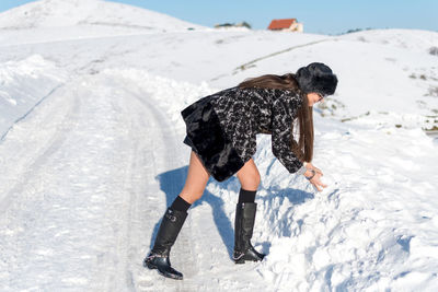 Rear view of man walking on snow covered land