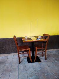 Empty chairs and tables against wall