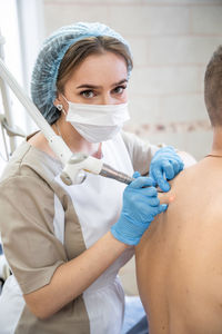 Portrait of young woman applying medicine at clinic