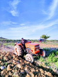 Man and tractor on field against sky