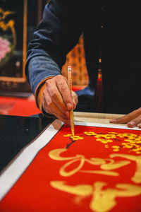 Midsection of man holding red table