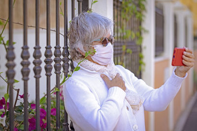 Senior woman doing selfie while standing outdoors