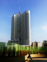 Modern buildings in city against blue sky