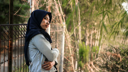 Side view of young woman standing on land