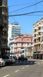Cars on street in city against clear sky
