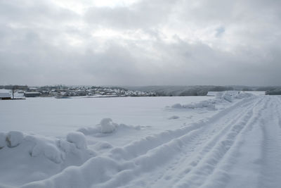 Snow covered landscape against sky