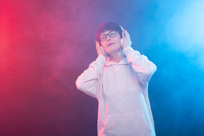 Full length of young man standing against pink background
