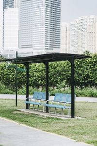 Empty park by swimming pool against buildings in city