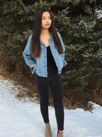 Portrait of young woman standing in park