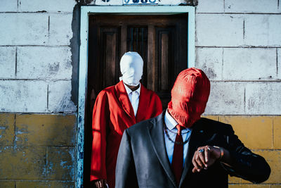 Rear view of woman standing against wall