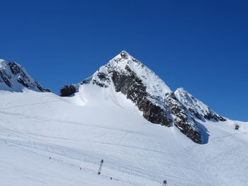 Scenic view of snowcapped mountains against clear blue sky