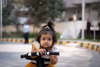Portrait of cute girl holding cycle looking with attitude