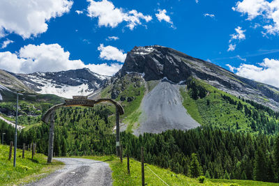 Road amidst green mountains against sky