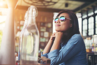 Thoughtful woman looking away while sitting at cafe table