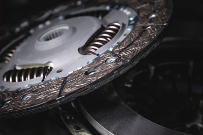 Close-up clutch disc of a car lies on metal parts contrast shot